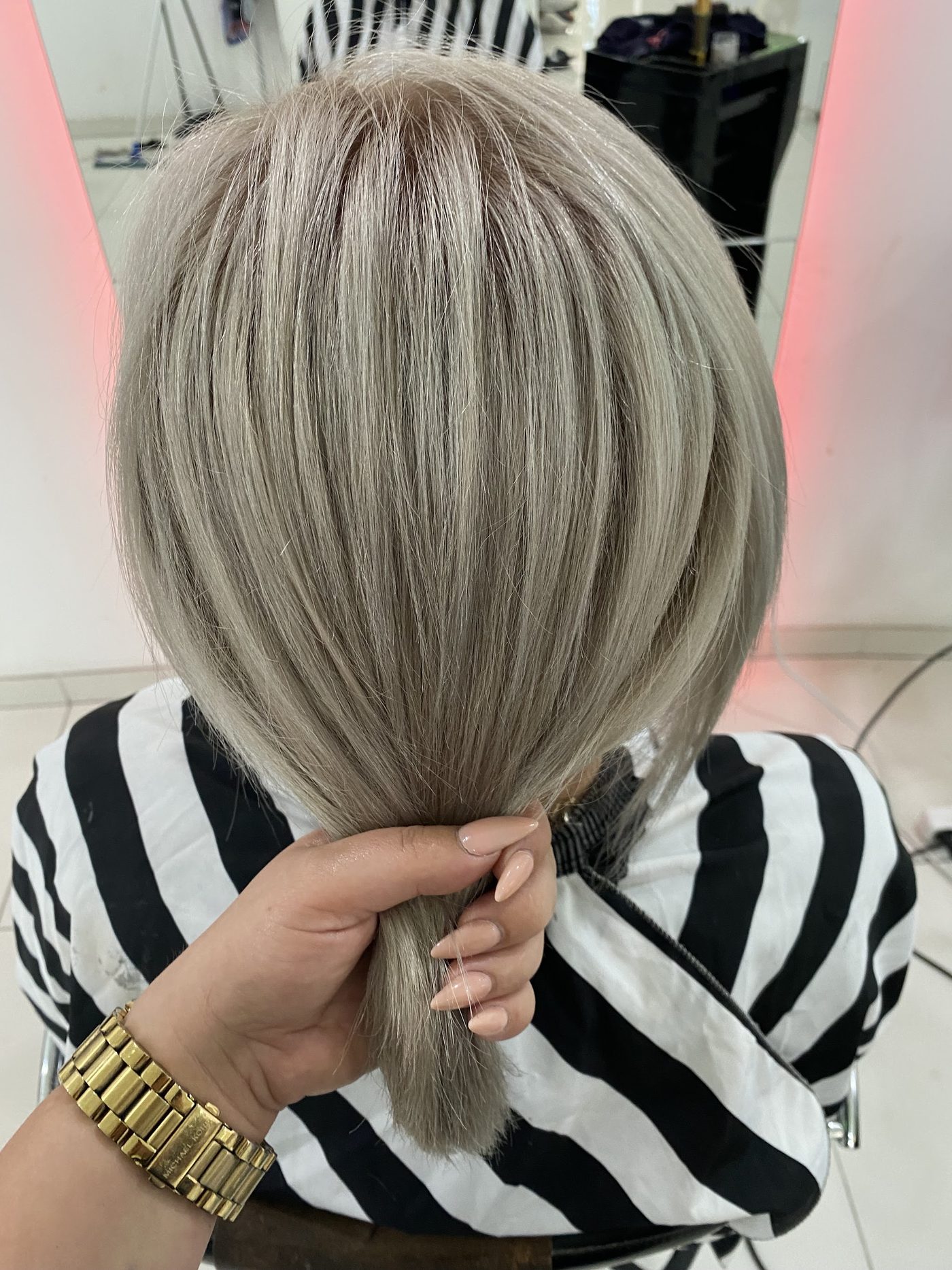 Lang asblond gekleurd haar, in de hand gehouden